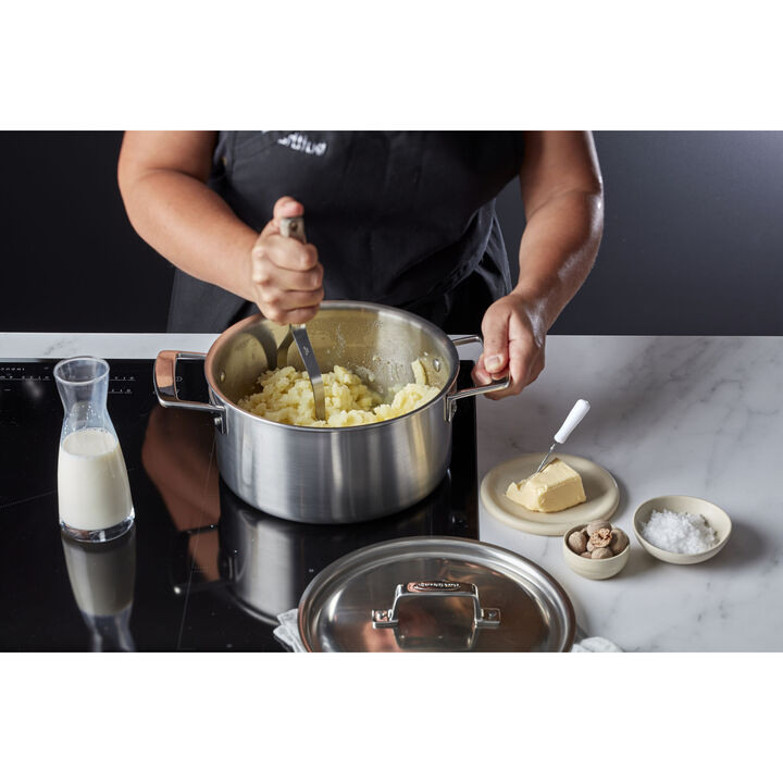 Demeyere Essential 5 kookpottenset met vijf roestvrijstalen pannen voor koken en stoofpotten, op een keukentafel.