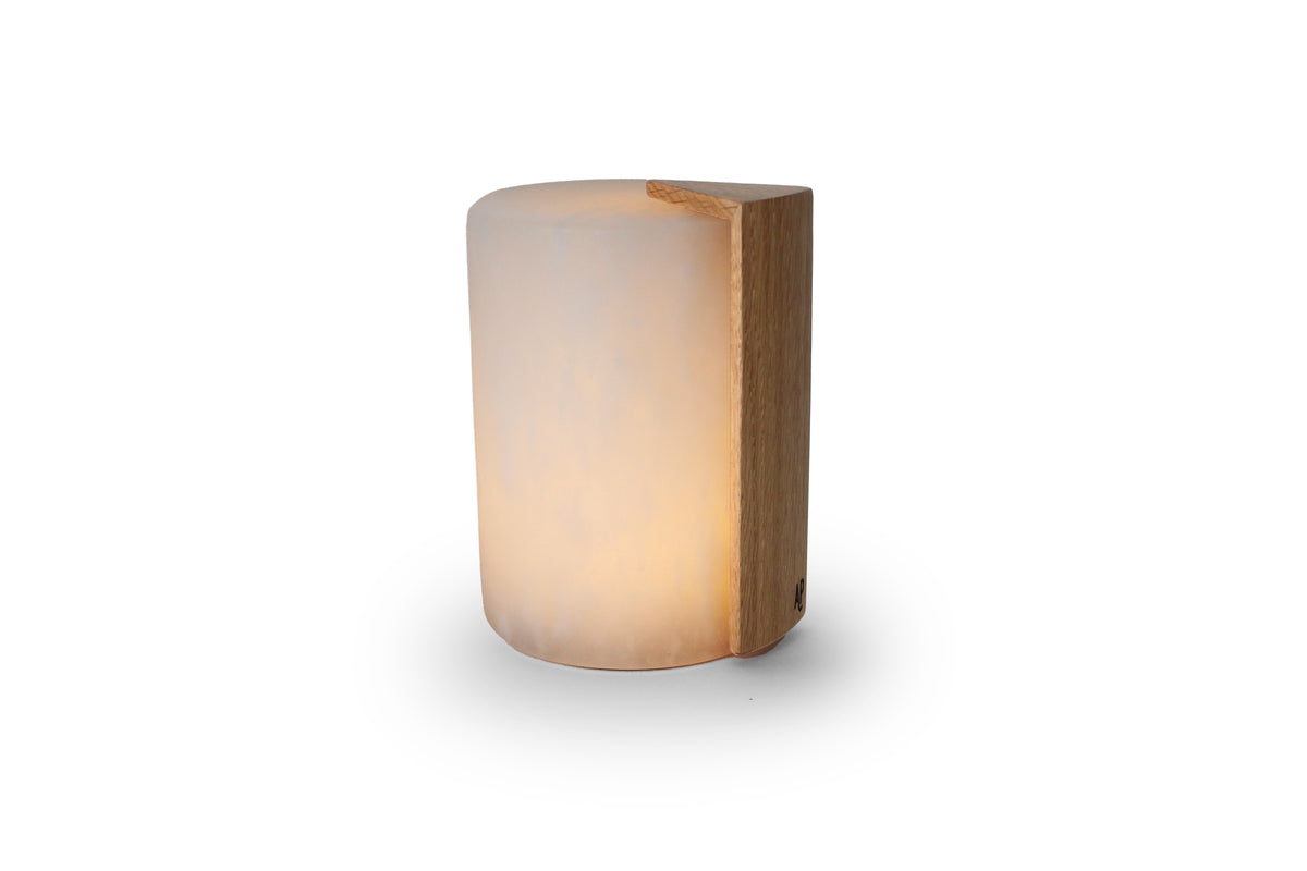 Oplaadbare lamp van Atelier Pierre met moderne verlichting en handvat, op tafel met zachte gloed en verstelbare lichtintensiteit.