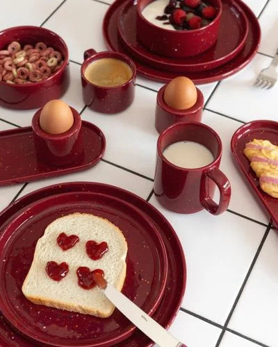 ONA Fika burgundy eierdopje op gedekte tafel, kleurrijk en stijlvol voor het serveren van eieren.
