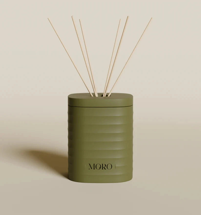 Moro geurdiffuser met agarhout- en ambergeur naast geurkaars voor sfeervolle geurverspreiding