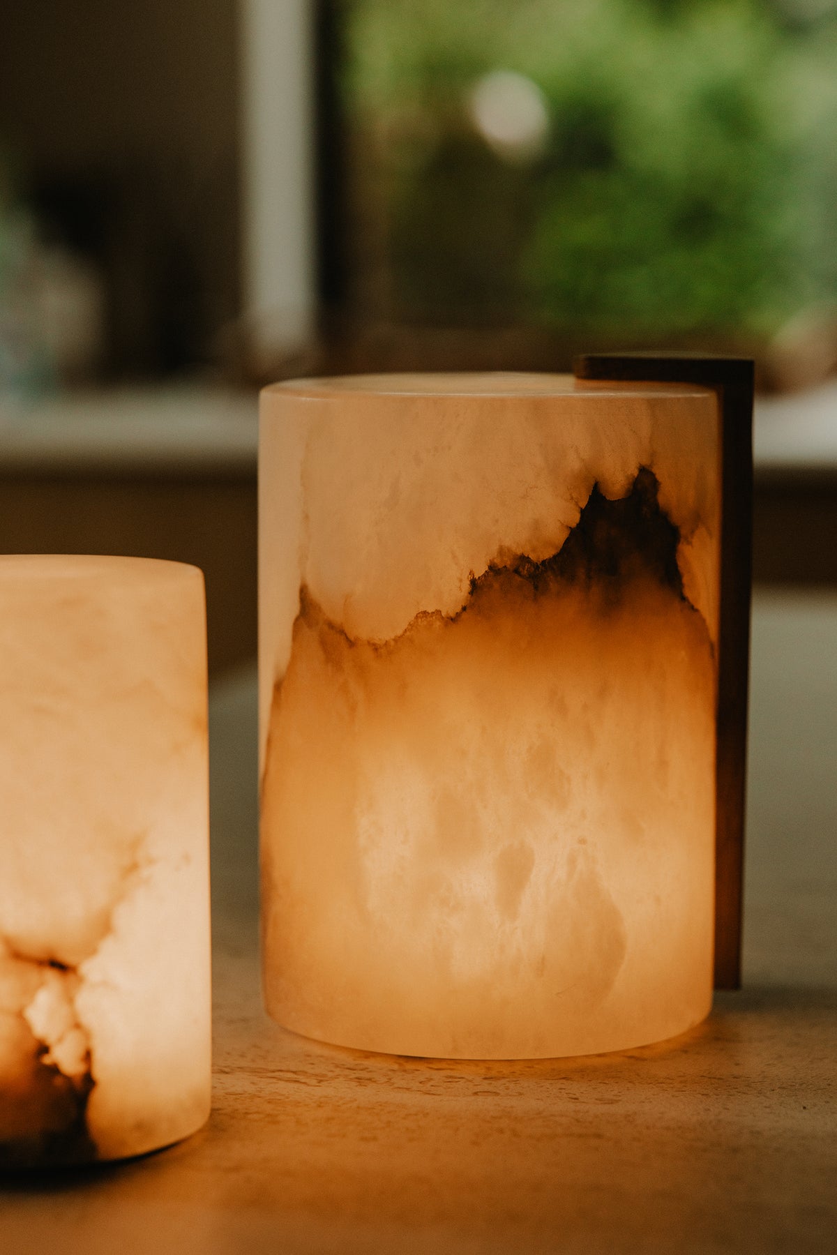 Oplaadbare lamp van Atelier Pierre met witte behuizing en handvat, ideaal voor sfeerverlichting en buitengebruik.